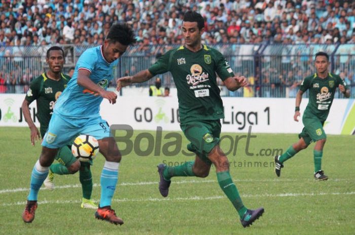 Gelandang Persela, Syahroni, berusaha menggiring bola melewati bek Persebaya, Otavio Dutra, dalam laga pekan kedua Liga 1 2018 di Stadion Surajaya, Lamongan, Jumat (30/3/2018)