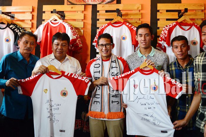 Direktur Persija Jakarta Gede Widiade (dua dari kiri), Wakil Walikota Jakarta Terpilih Sandiaga Uno, dan Pemain Persija Jakarta Ryuji Utomo berpose dengan jersey Persija yang mereka tanda tangani dalam launching Original Store Persija yang terletak di Rawasari, Jakarta Pusat, pada Selasa (12/9/2017)