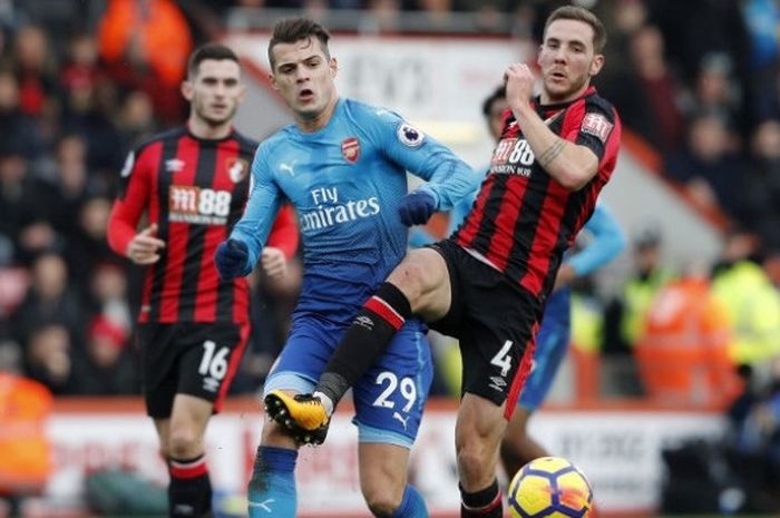 Gelandang Arsenal, Granit Xhaka, berduel dengan gelandang  Bournemouth, Dan Gosling, dalam laga Liga Inggris antara kedua tim di Stadion Vitality, Minggu (14/1/2018).