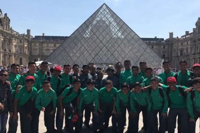 Tim nasional U-19 Indonesia berfoto dengan latar belakang Musee Du Louvre, Perancis. 