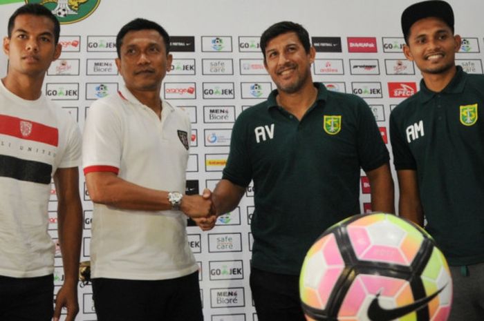 Pelatih Bali United Widodo C Putra (dua dari kiri) berjabat tangan dengan pelatih Persebaya, Angel Alfredo Vera (dua dari kanan), pada sesi jumpa awak media, Jumat (6/7/2018).
