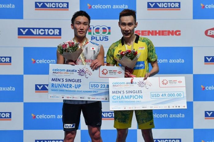   Pebulu tangkis tunggal putra Jepang, Kento Momota (kiri) dan Lee Chong Wei (Malaysia) berpose di podium masing-masing sebagai runner-up dan juara pada Malaysia Open yang berlangsung di Axiata Arena, Kuala Lumpur, Minggu (1/7/2018).  