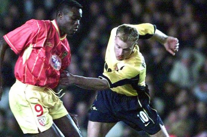 Dennis Bergkamp (kanan) berusaha melewati Alex Nyarko dalam partai Piala UEFA antara Arsenal kontra RC Lens di Highbury, London, 6 April 2000.