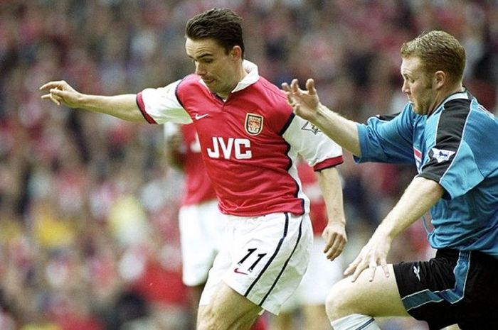 Marc Overmars (Arsenal, kiri) beraksi dengan Steve Watson (Aston Villa), pada pekan terakhir Premier League 1998/99. Walau Arsenal menang 1-0, mereka tidak bisa mempertahankan trofi Premier League.