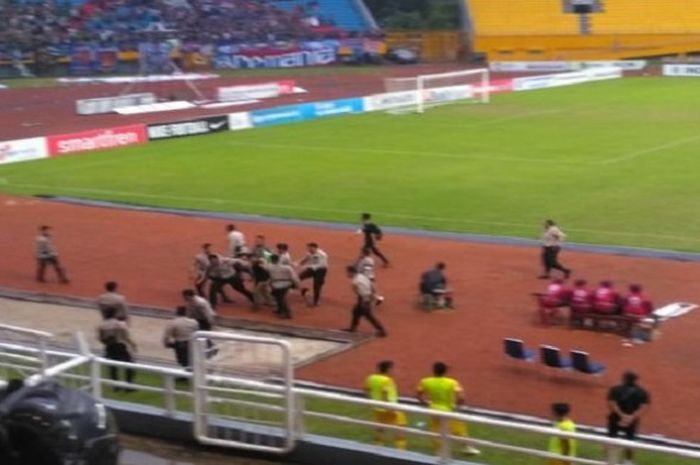 Petugas keamanan menangkap suporter yang masuk lapangan dalam laga antara Sriwijaya FC Vs Arema FC di Stadion Gelora Sriwijaya Jakabaring (GSJ) Palembang, Sabtu (21/7/2018)