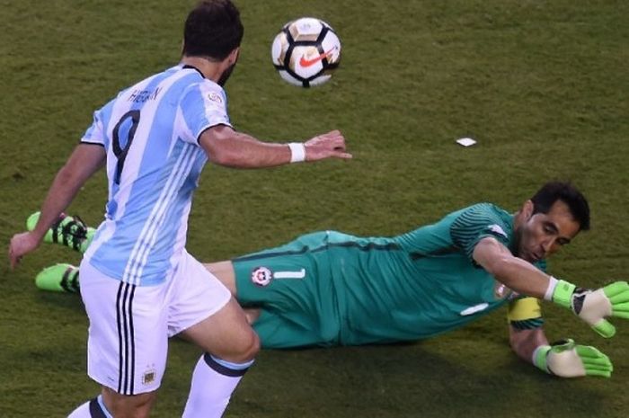 Striker Argentina, Gonzalo Higuain, berupaya menendang bola melewati kiper Cile, Claudio Bravo, dalam laga final Copa America Centenario di East Rutherford, New Jersey, pada 26 Juni 2016.