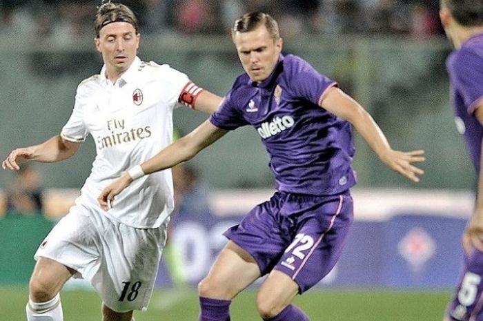 Gelandang sekaligus kapten AC Milan, Riccardo Montolivo (kiri), berupaya merebut bola dari gelandang Fiorentina, Josip Ilicic, dalam laga Serie A di Stadion Artemio Franchi, Minggu (25/9/2016) atau Senin dini hari WIB.