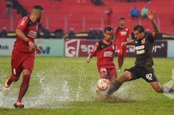 Pemain Semen Padang, Riko Simanjuntak (20) berebut bola dengan gelandang Pusamania Borneo FC, Flavio Junior pada lapangan becek di Stadion H Agus Salim, Jumat (11/11/2016). 
