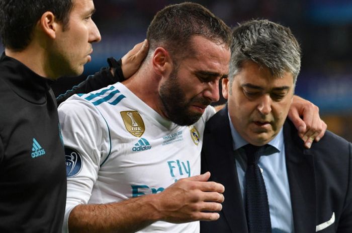 Bek sayap kanan Real Madrid, Daniel Carvajal (tengah), menangis saat meninggalkan lapangan pertandingan akibat mengalami cedera pada laga final Liga Champions 2017-2018 menghadapi Liverpool di Stadion NSC Olimpiyskiy, Kiev, Ukraina, pada Sabtu (26/5/2018).