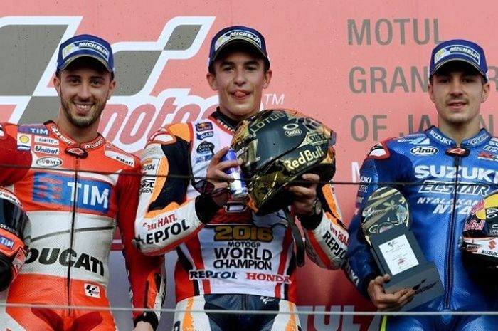 Pebalap Repsol Honda Marc Marquez (tengah), berpose dengan Andrea Dovizioso (Ducati-kiri) dan Maverick Vinales (Suzuki Ecstar-kanan) di podium setelah memastikan diri finis pertama pada GP Jepang yang berlangsung di Sirkuit Twin Ring Motegi, Minggu (16/10/2016).