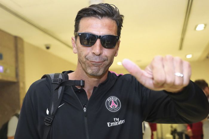 Kiper Paris Saint-Germain, Gianluigi Buffon, mengacungkan jempol kepada kamera ketika timnya tiba di