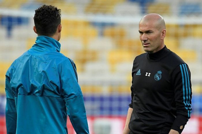 Pelatih Real Madrid, Zinedine Zidane (kanan), berbicara dengan Cristiano Ronaldo dalam sesi latihan di Stadion Olimpiyskiy, Kiev, Ukraina pada 25 Mei 2018.