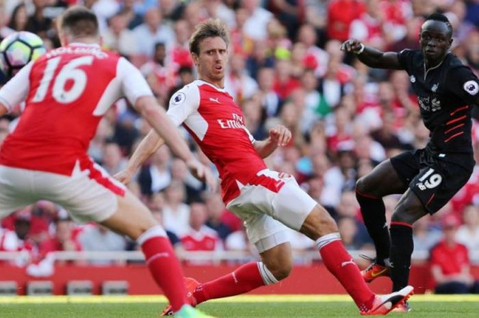 Penyerang sayap Liverpool, Sadio Mane (kanan), melepaskan tembakan yang berbuah gol ke gawang Arsenal dalam laga perdana mereka di Liga Inggris 2016-2017 pada duel di Emirates Stadium, 14 Agustus 2016.