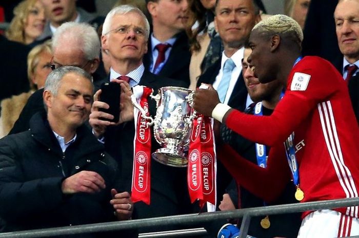 Gelandang Manchester United, Paul Pogba, memberikan trofi Piala Liga Inggris kepada manajer Jose Mourinho setelah mengalahkan Southampton dalam partai final di Stadion Wembley, London, Inggris, pada 26 Februari 2017.