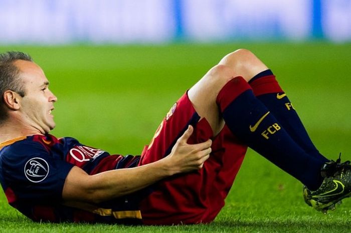 Gelandang Barcelona, Andres Iniesta, terduduk di lapangan sambil kesakitan akibat cedera dalam partai Liga Champions lawan Bayer Leverkusen di Camp Nou, 29 September 2015.