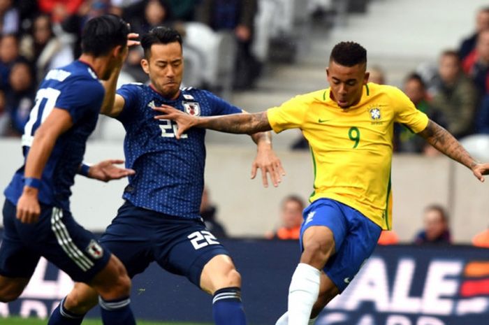Bek timnas Jepang, Maya Yoshida (tengah), berduel dengan striker timnas Brasil, Gabriel Jesus, dalam laga persahabatan.