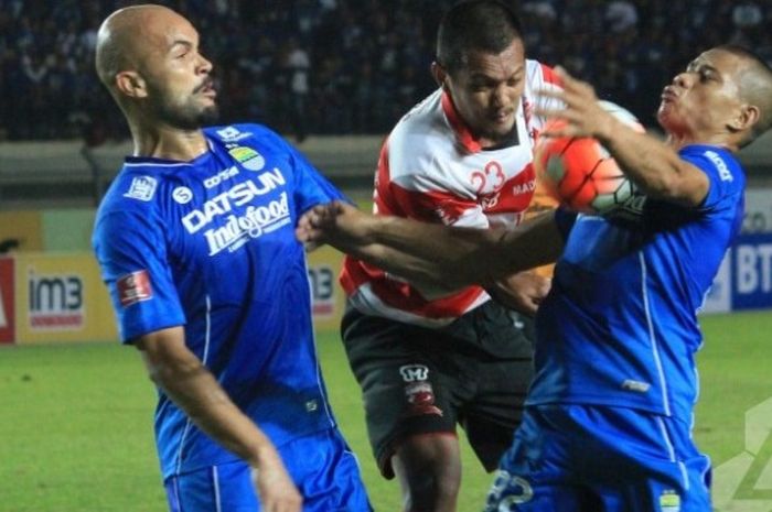 Duel antara duo Persib, Sergio van Dijk (kiri) dan Tantan yang mengapit gelandang Madura United, Gilang Ginarsa di Stadion Si Jalak Harupat, Kab Bandung, Sabtu (28/5/2016). 