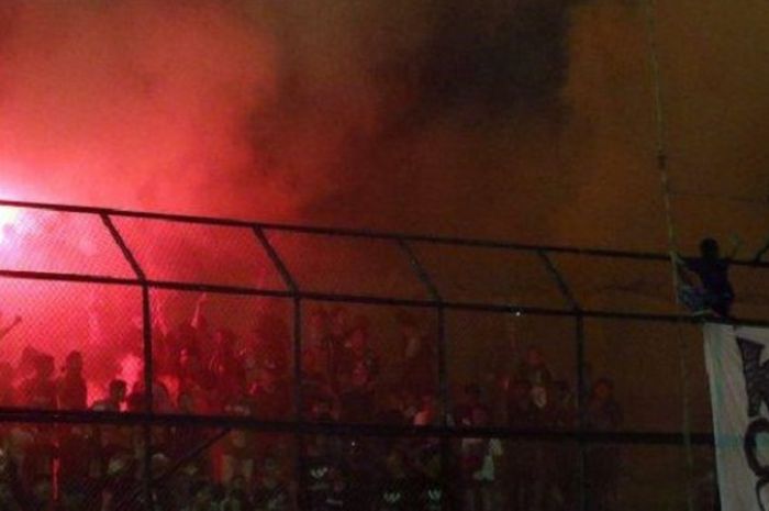 Flare menyala saat laga PSMS Medan kontra Persebaya Surabaya, Sabtu (1/12/2018).