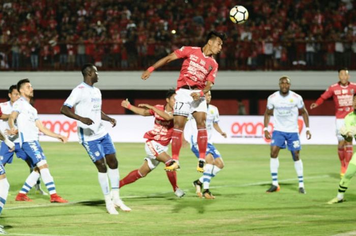  Lompatan pemain Bali United, Nyoman Sukarja di antara rekan setim dan pemain Persib pada laga lanjutan Liga 1 2018 di Stadion Kapten I Wayan Dipta, Gianyar, Minggu (27/5/2018) malam.  