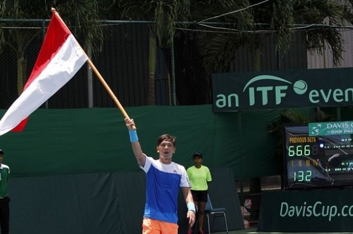 Petenis Indonesia, Christopher Rungkat, mengibarkan bendera Merah Putih seusai mengalahkan Kuwait 4-1 pada Piala Davis Grup II Zona Asia/Oseania di Lapangan Tenis Manahan, Solo, Minggu (9/4/2017).