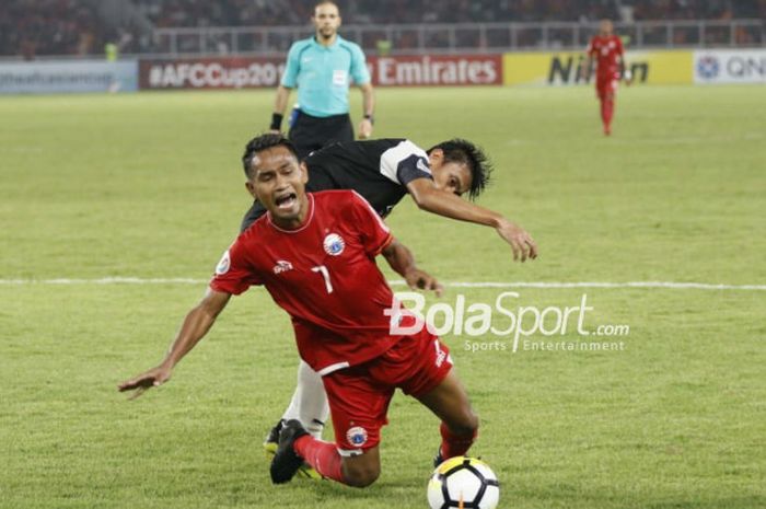 Gelandang Persija Jakarta, Ramdani Lestaluhu, terjatuh saat berduel kontra pemain Home United pada l