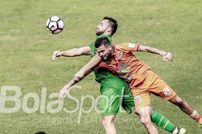 Penyerang Bhayangkara FC, Ilija Spasojevic, berduel dengan bek Borneo FC, Diego Michiels, pada lanjutan laga Liga 1, 20 September 2017.