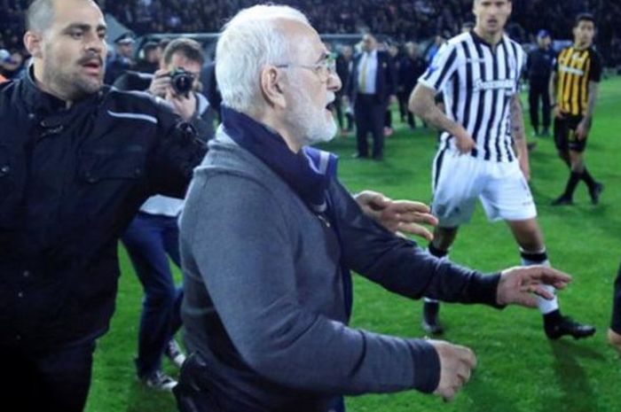 Presiden PAOK Salonika, Ivan Savvidis (tengah), masuk ke lapangan di tengah pertandingan timnya melawan AEK Athena di Athena, Yunani, Minggu (11/3/2018) waktu setempat.