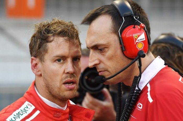 Pebalap Ferrari asal Jerman, Sebastian Vettel (kiri), berdiskusi dengan kru sebelum balapan GP Bahrain di Sirkuit Internasional Bahrain, Sakhir, Minggu (16/4/2017).