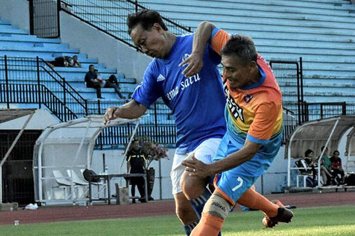 Pemain Mitra Devata, Purwanto Iman Santoso (kiri/biru) berduel dengan pemain Madya 90 Magelang di Stadion Mohammad Soebroto, Magelang, Jawa Tengah, Minggu (29/4/2018).