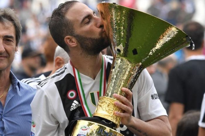 Penyerang Juventus, Gonzalo Higuain, mencium trofi juara Liga Italia dalam perayaan gelar timnya setelah pertandingan lawan Hellas Verona di Stadion Allianz Stadium Turin, 19 Mei 2018.