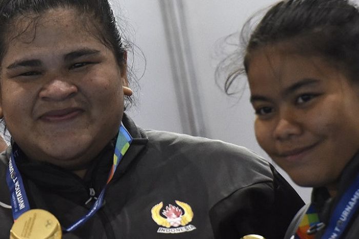 Lifter Indonesia Melinda Gusti (kanan) dan Nurul Akmal menunjukkan medali emas yang mereka peroleh pada nomor angkat besi putri 75 dan +75 kg 18th Asian Games Invitation Tournament di JiExpo, Jakarta, Senin (12/2/2018).