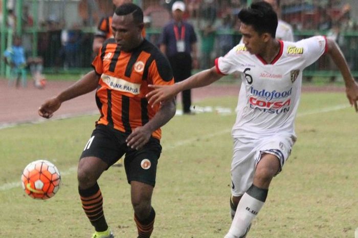 Bek Bali United, Felsianus Bate (kanan), berusaha merebut bola dari kaki penyerang Perseru Serui, Yoksan Ama (kiri), pada laga kedua tim di Stadion Marora, Serui, Sabtu (22/10/2016).