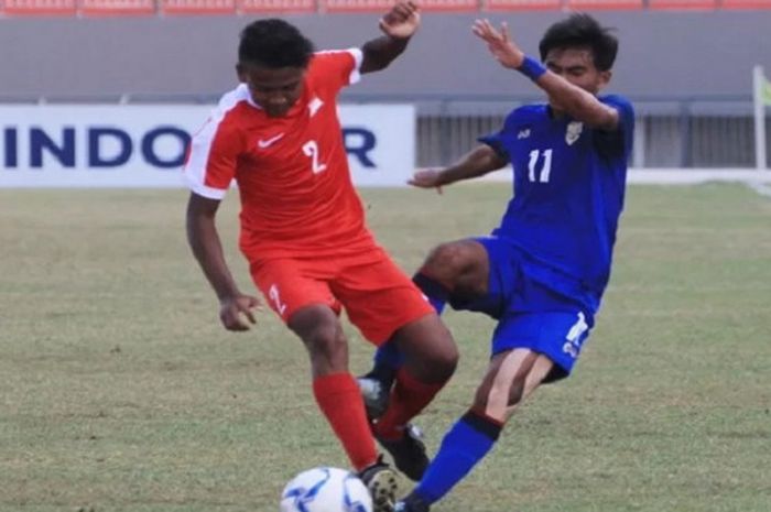 Bek Timnas U-16 Singapura Aniq Raushan (kiri) berebut bola dengan striker Timnas U-16 Thailand Kittiphong Khetpara dalam duel Grup B Piala AFF U-16 2018 di Stadion Gelora Joko Samudro, Gresik, Jawa Timur, Jumat (3/8/2018) sore WIB.