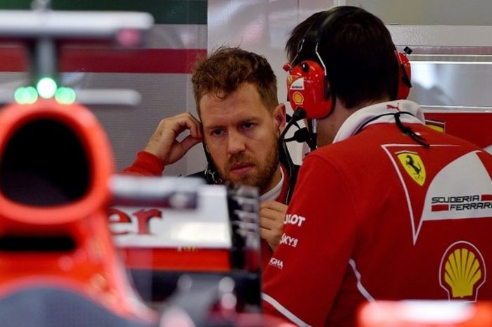 Pebalap Formula 1 (F1) yang membela tim Ferrari, Sebastian Vettel (kiri), bersiap menjalani sesi latihan kedua GP Australia yang berlangsung di  Sirkuit Melbourne Grand Prix, Albert Park, Jumat (24/3/2017).