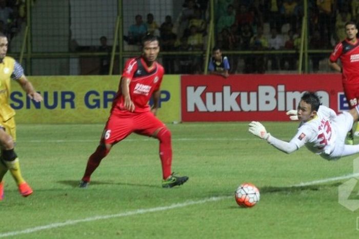 Kiper Semen Padang, Rivky Mokodompit (kanan) terbang menghalau sepakan pemain Barito Putera di Stadion 17 Mei, Banjarmasin, Jumat (17/6/2016) malam. 