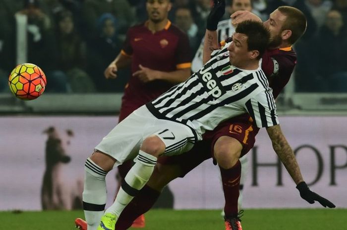 Duel antara penyerang Juventus, Mario Mandzukic (depan) dengan pemain Roma, Daniele De Rossi, dalam partai kedua tim di Juventus Stadium, 24 Januari 2016.