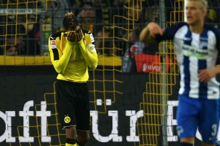Penyerang Borussia Dortmund, Pierre-Emerick Aubameyang, menutup wajahnya setelah gagal mengeksekusi penalti ke gawang Hertha BSC Berlin di Stadion Signal Iduna Park, Dortmund, Jumat (14/10/2016). 