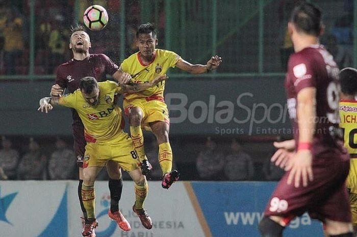Gelandang bertahan PSM Makassar Marc Klok berebut bola dengan dua pemain Bhayangkara FC di Stadion Patriot, Kamis (19/10/2017).