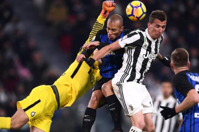 Kiper Inter Milan, Samir Handanovic, mencoba menghalau bola di tengah rebutan antara Mario Mandzukic (Juventus) dan Miranda dalam partai Liga Italia di Allianz Stadium Turin, 9 Desember 2017.