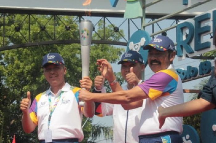 Irjen Pol. Condro Kirono (kiri) saat menerima obor Asian Games 2018 dari Walikota Solo, FX Hadi Rudyatmo (ketiga dari kiri) pada acara torch relay Asian Games 2018 yang berlangsung di Solo, Kamis (19/7/2018).