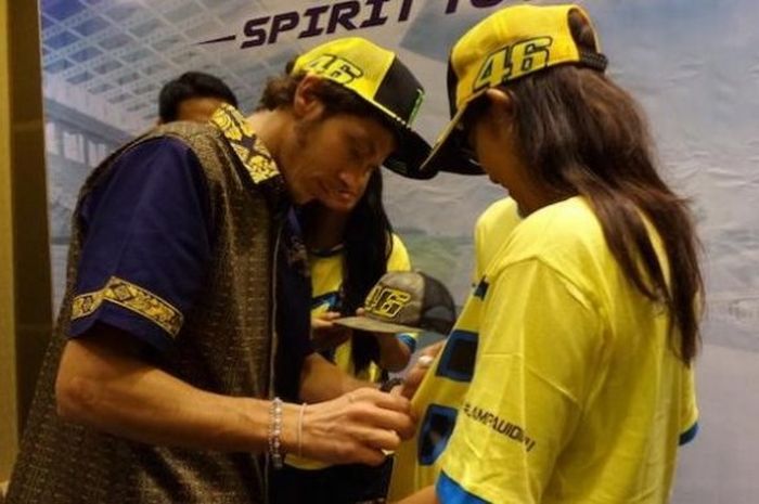 Pebalap Movistar Yamaha asal Italia, Valentino Rossi, menandatangani kaus salah satu penggemar yang hadir pada acara meet and greet di Hotel Mulia, Nusa Dua, Bali, Selasa (26/1/2016).