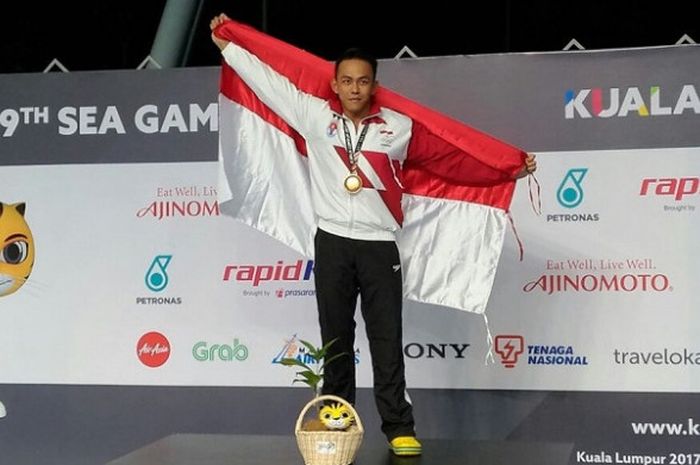 Perenang putra nasional, Indra Gunawan, berpose di atas podium setelah meraih medali emas SEA Games 2017 pada nomor 50 meter gaya dada yang berlangsung di National Indoor Stadium, Bukit Jalil, Sabtu (26/8/2017).