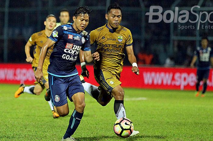 Gelandang Arema FC, Adam Alis (kiri), adu lari dengan gelandang Persib Bandung, Tony Sucipto, saat berebut bola dalam laga pekan ke-19 Liga 1 di Stadion Kanjuruhan Malang, Jawa Timur, Sabtu (12/08/2017) malam.