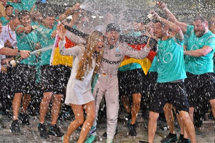 Pebalap Mercedes, Nico Rosberg, dan sang istri, Vivian Sibold, merayakan keberhasilan meraih gelar juara dunia Formula 1 (F1) musim ini bersama kru tim di paddock Sirkuit Yas Marina yang menjadi arena balapan GP Abu Dhabi, Minggu (27/11/2016).