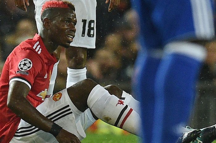 Gelandang andalan Manchester United, Paul Pogba terduduk di atas lapangan pertandingan karena cedera yang ia dapat saat melawan Basel, Rabu (13/9/2017).