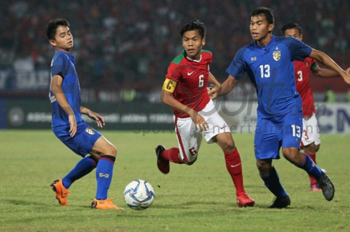 Gelandang timnas U-16 Indonesia, David Maulana di antara dua pemain timnas U-16 Thailand pada final Piala AFF U-16 2018 di Stadion Gelora Delta, Sidoarjo, 11 Agustus 2018. 