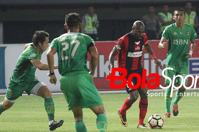Penyerang Persipura Jayapura Boaz Solossa berusaha meloloskan diri dari tiga kawalan Bhayangkara FC di Stadion Patriot, Sabtu (9/9/2017).