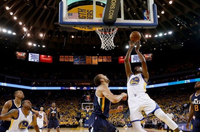 Forward Golden State Warriors, Kevin Durant (jersey putih, #35), melepas lay-up seraya dijaga pemain Utah Jazz, Rudy Gobert (#27), pada laga gim kedua babak semifinal play-off NBA Wilayah Barat di Oracle Arena, Oakland, California, Kamis (4/5/2017) malam waktu setempat. Warriors menang dengan skor 115-104.