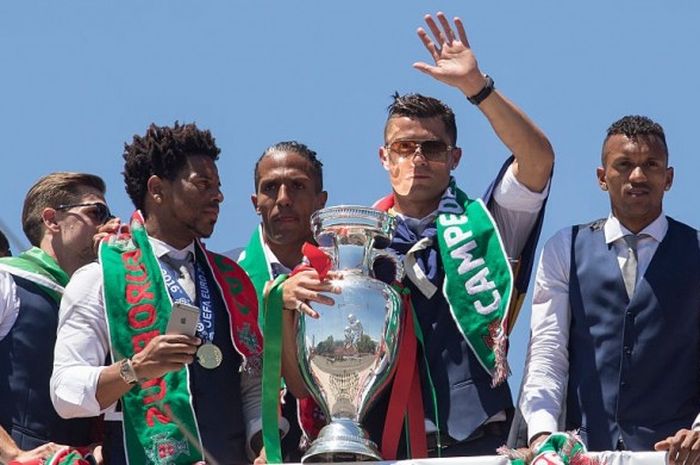 Bruno Alves berdiri di sebelah kiri Cristiano Ronaldo yang memegang trofi Piala Eropa 2016 dalam perayaan di Lisbon, Portugal, 11 Juli 2016.