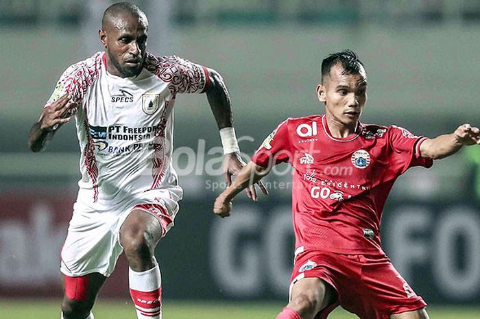  Gelandang Persija Jakarta, Riko Simanjuntak (kanan) berebut bola dengan striker Persipura Jayapura, Boaz Solossa, saat kedua tim bertemu pada laga pekan ke-10 Liga 1 2018 diStadion Pakansari, Kabupaten Bogor, Jumat (25/5/2018) Malam. 